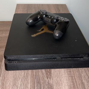 All black PlayStation 4 slim console with a DualShock 4 controller